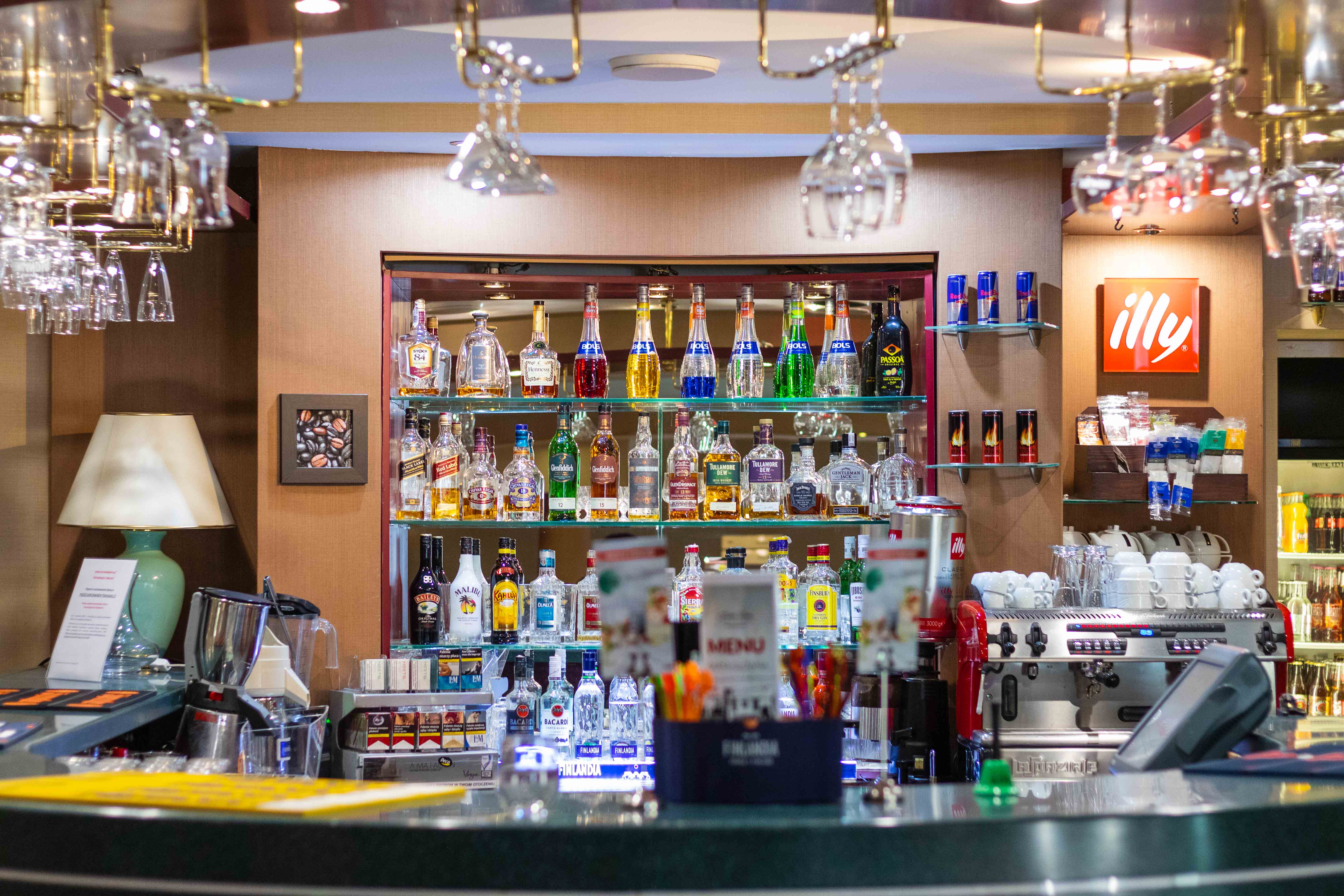 Hotel Boss Warszawa: bar front view with hanging glasses and alcohol bottles at the back